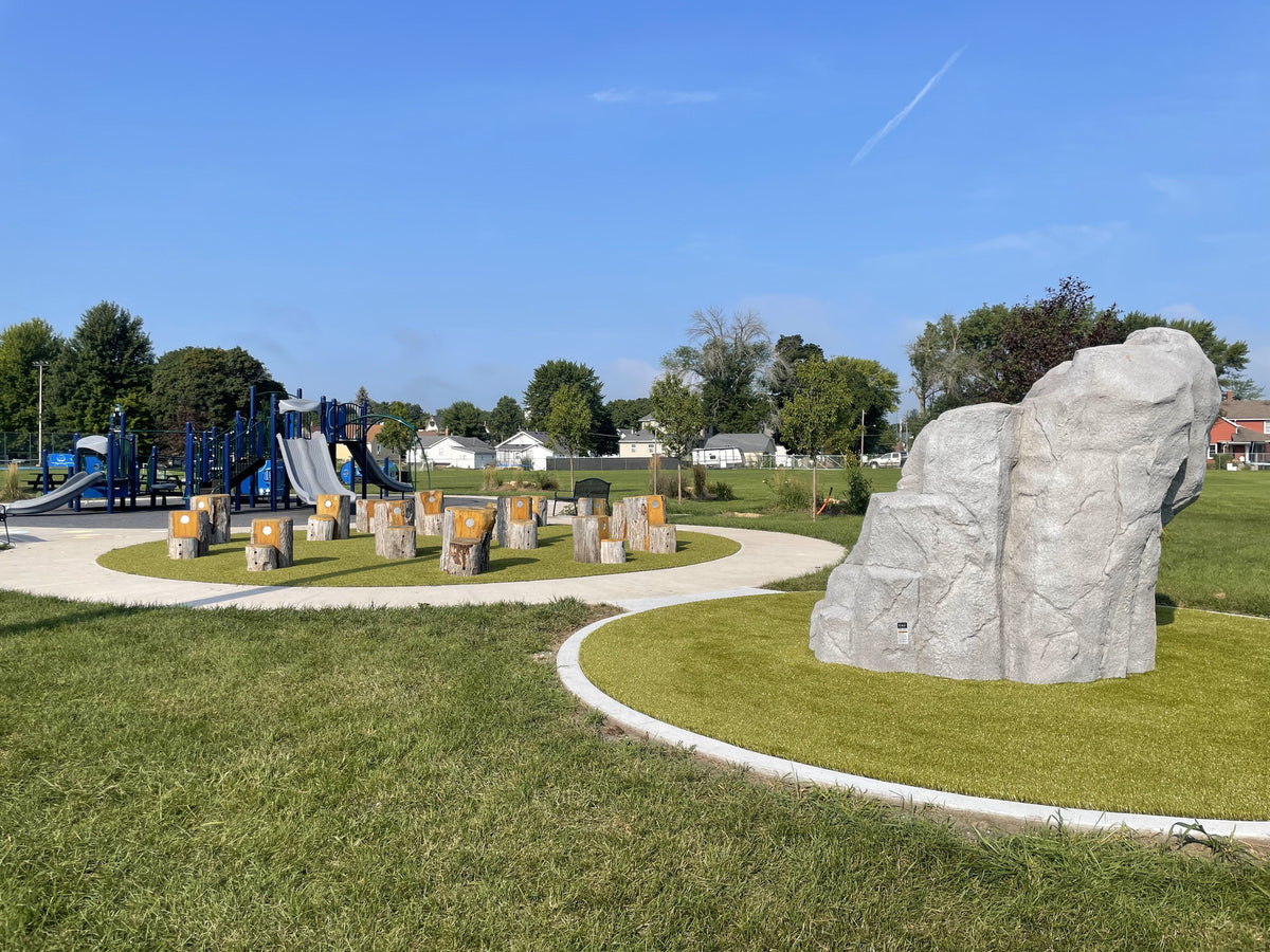 Playground featuring climbing rock and wooden stumps