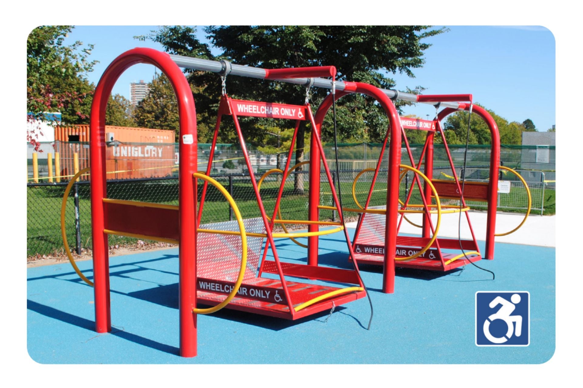 Freedom Glider ADA Accessible Swing Set platform with red frames, yellow handrails, wheelchair access, on blue safety surface