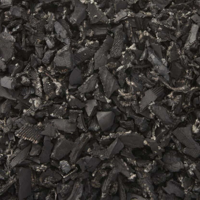 Black recycled rubber mulch with visible textile fibers, designed for durable, safe playground surfacing.