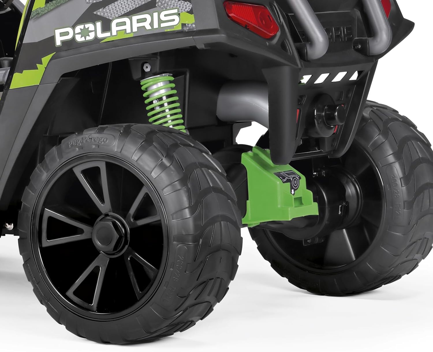 Close-up of rear rugged tires, suspension, and shock absorbers on green and black off-road ride-on vehicle
