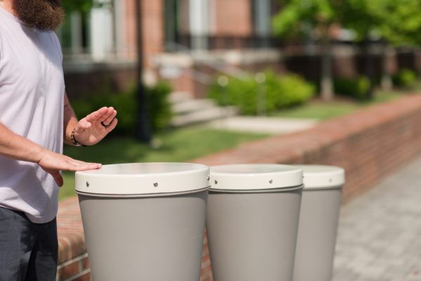 Three taupe synthetic outdoor drums in large, medium, and small sizes with a person playing the largest drum