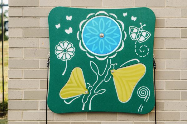 Outdoor musical panel with colorful botanical and butterfly designs, featuring bell-like plates for interactive play.