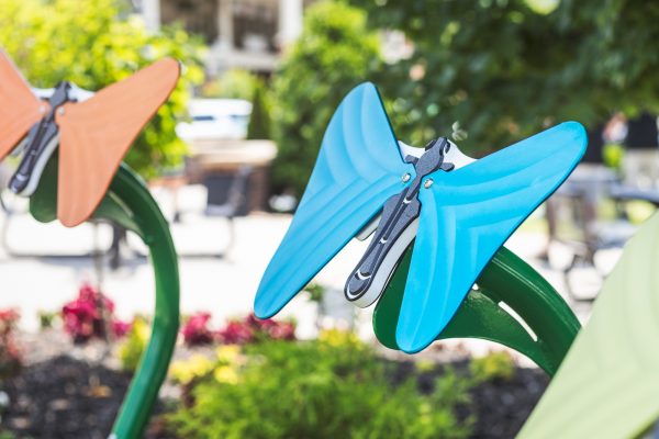 Colorful toddler outdoor musical butterflies with anodized aluminum notes on green stems in a garden setting