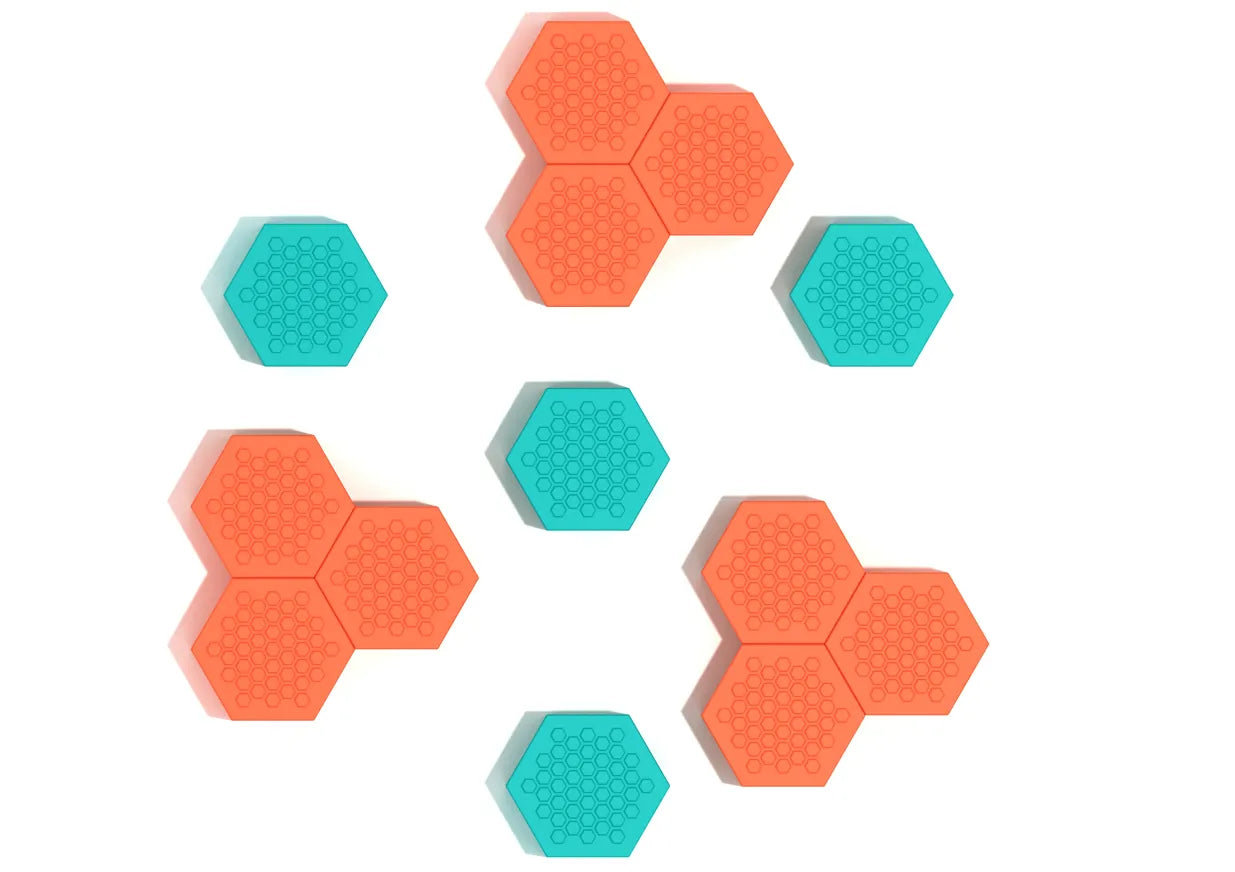 Overhead view of colorful hexagonal climbing pods with textured tops in orange and teal for active play