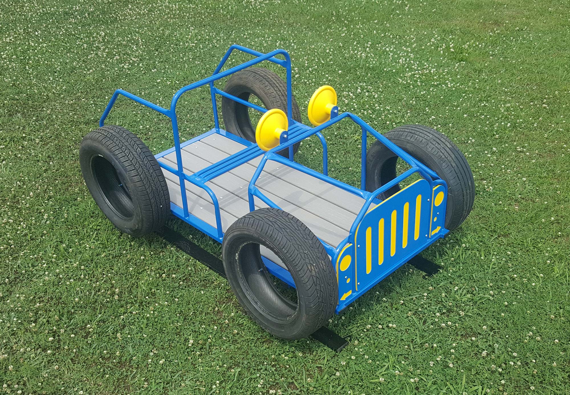 Blue and yellow metal jeep-shaped spring rider with black wheels on grass playground surface