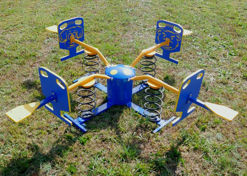 Four-person blue and yellow spring rider with animal face panels and seats on grassy outdoor play area