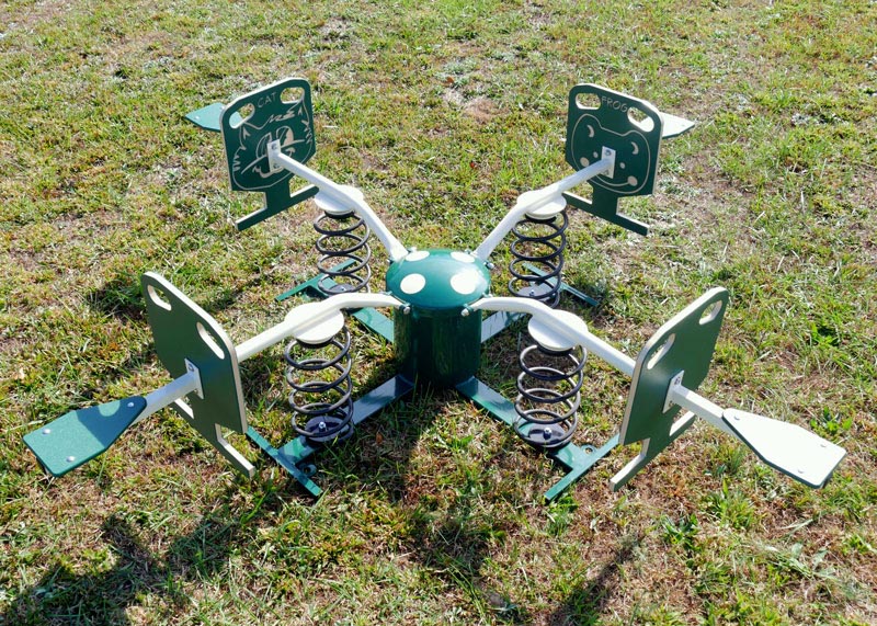 Four-person green and beige spring rider with animal-themed seats on grassy outdoor play area