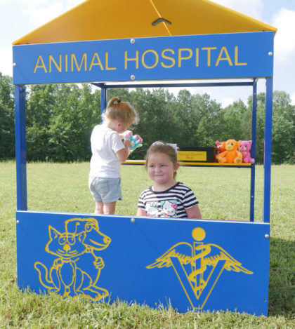 Animal Hospital Playhouse with yellow HDPE roof, blue panels featuring animal and veterinary symbols, children playing inside outdoors