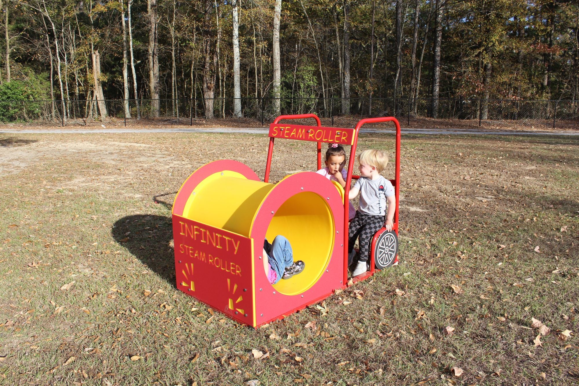 Steam Roller playground equipment with dual climbing tunnels and steering wheels, children playing outdoors on grass