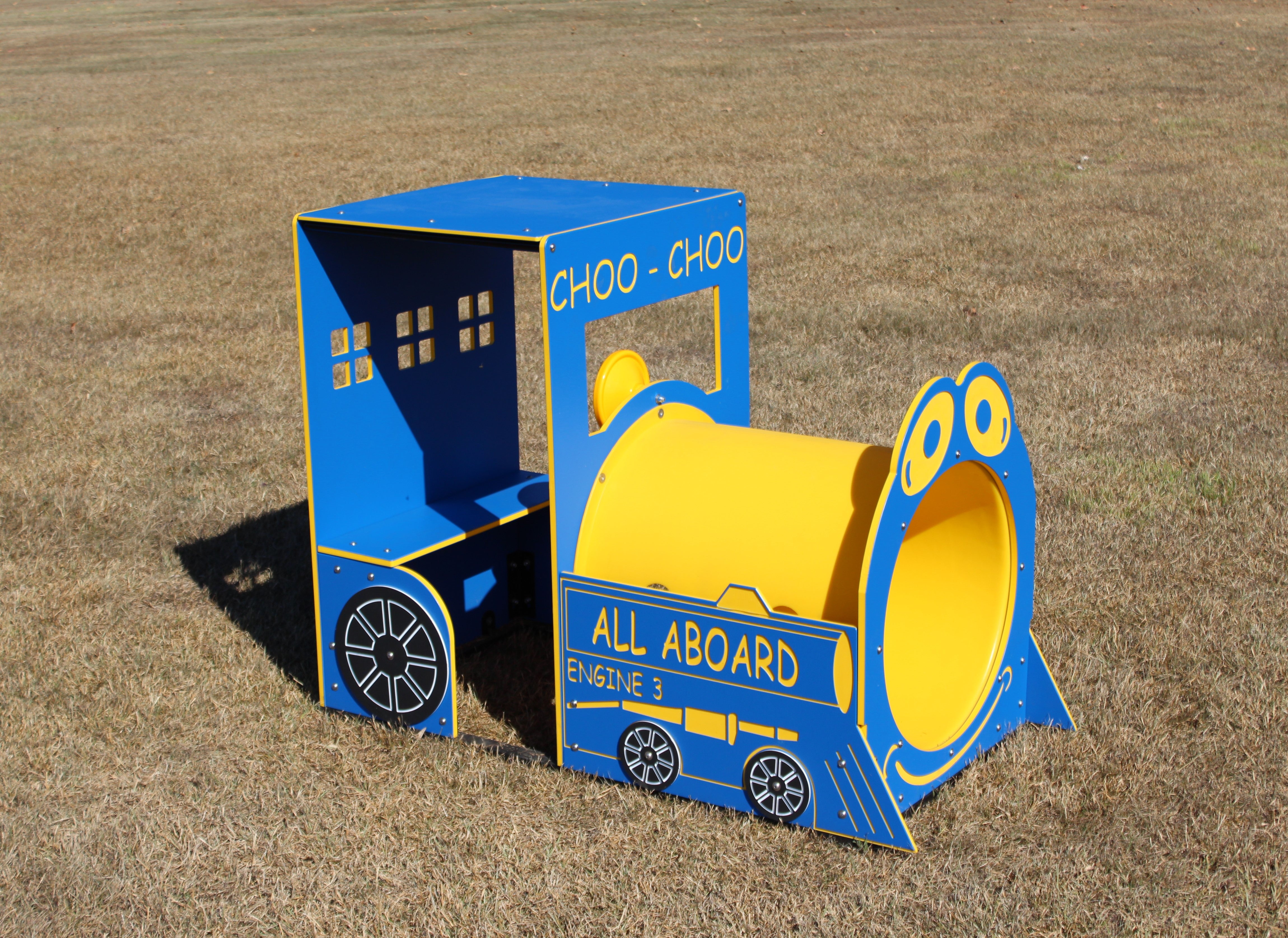 Blue and yellow outdoor playground train engine with tunnel and interactive play features on grass