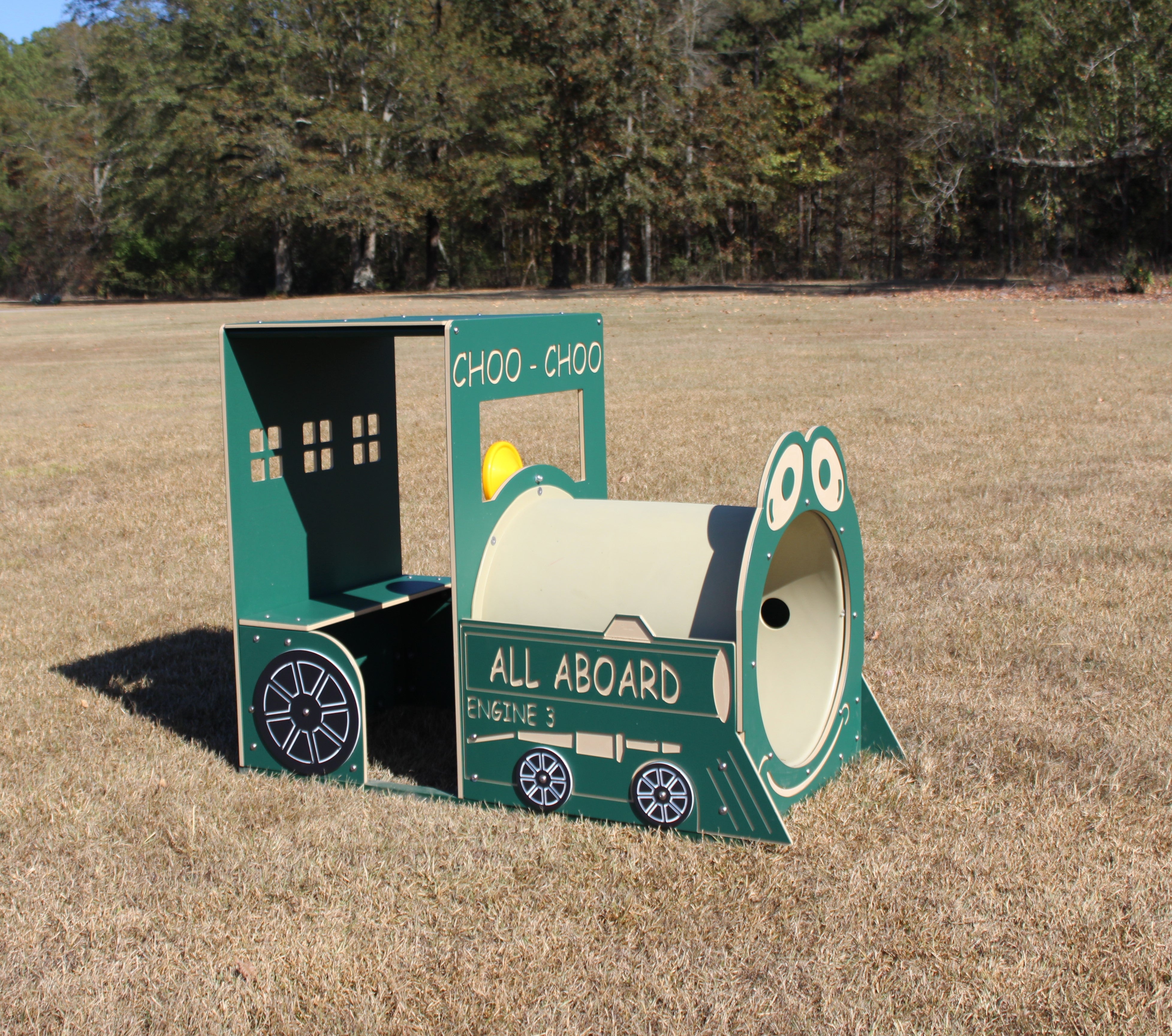 Green and beige outdoor play train engine with cartoon eyes, interactive tunnel, and bench seating on grass field