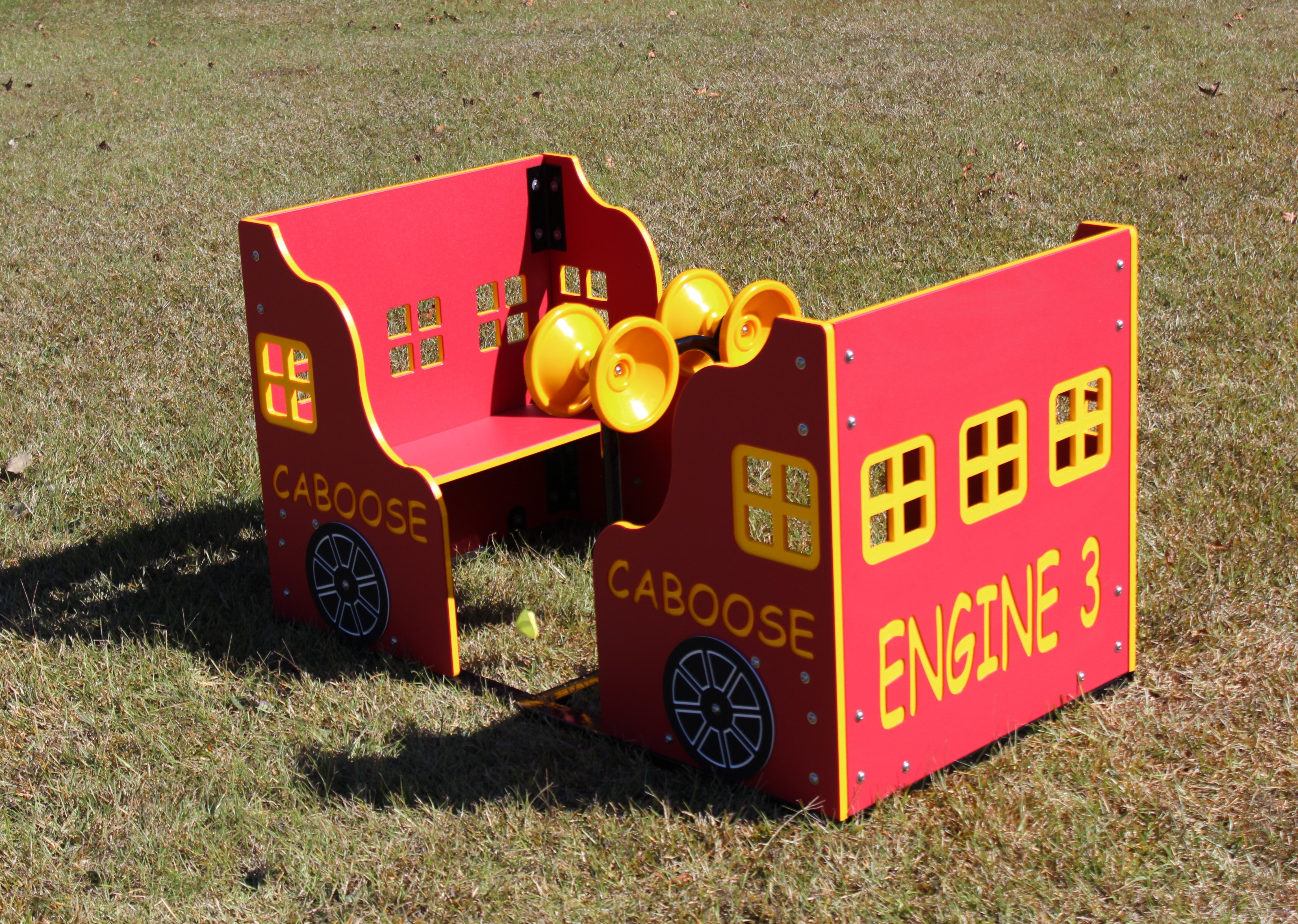Red and yellow outdoor play caboose with bench seating, windows, wheels, and interactive yellow horns on grass