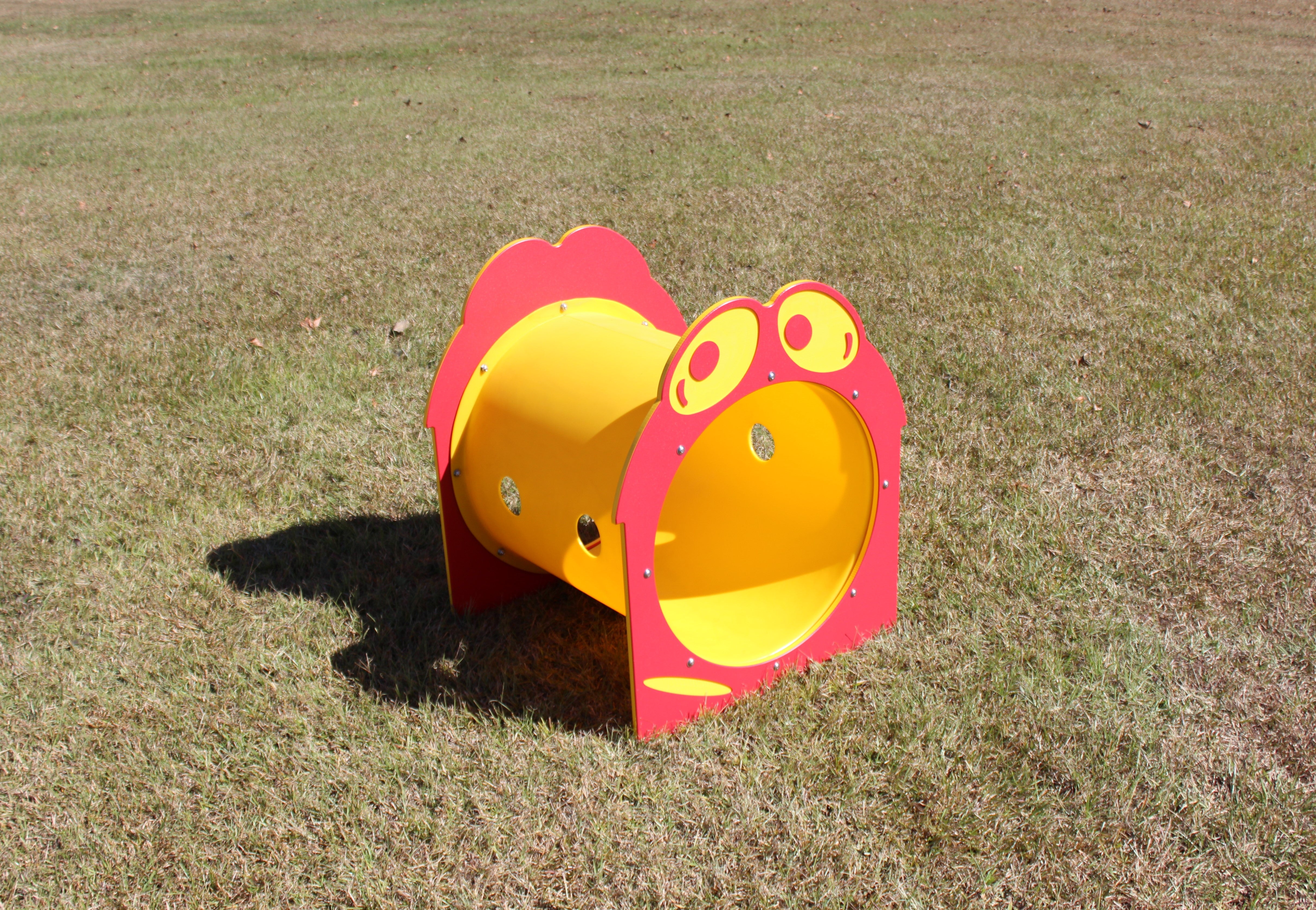 Silly Sam Playground Tunnel with bright yellow tube and red cartoon chicken face ends on grass, outdoor climbing tunnel for kids