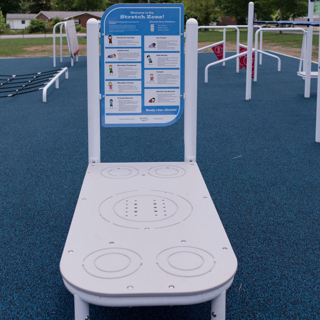 ActionFit Kids Stretch Zone outdoor workout equipment with instructional panel and kid-friendly stretch diagrams on blue safety surface