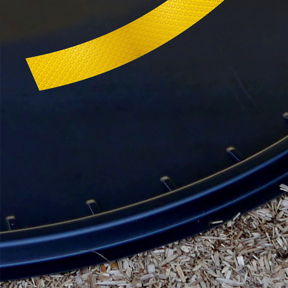 Curved yellow double solid traffic line from Tricycle Path Stripe Kit on black trike path piece with wood chip ground