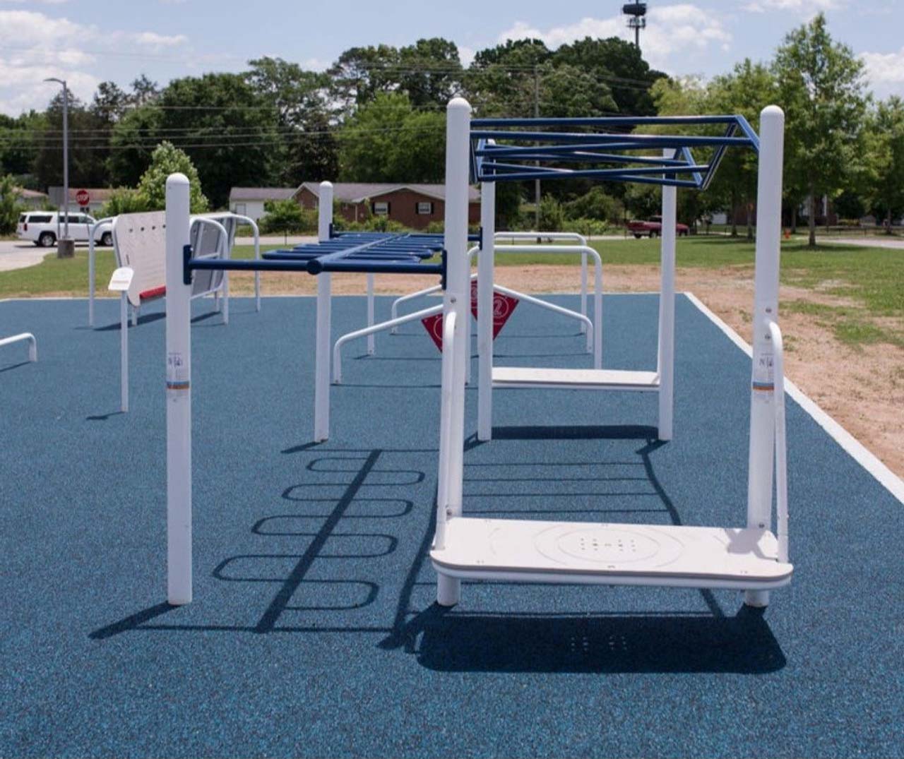 Outdoor kids' accessible strength training equipment with white and blue bars on blue safety surface