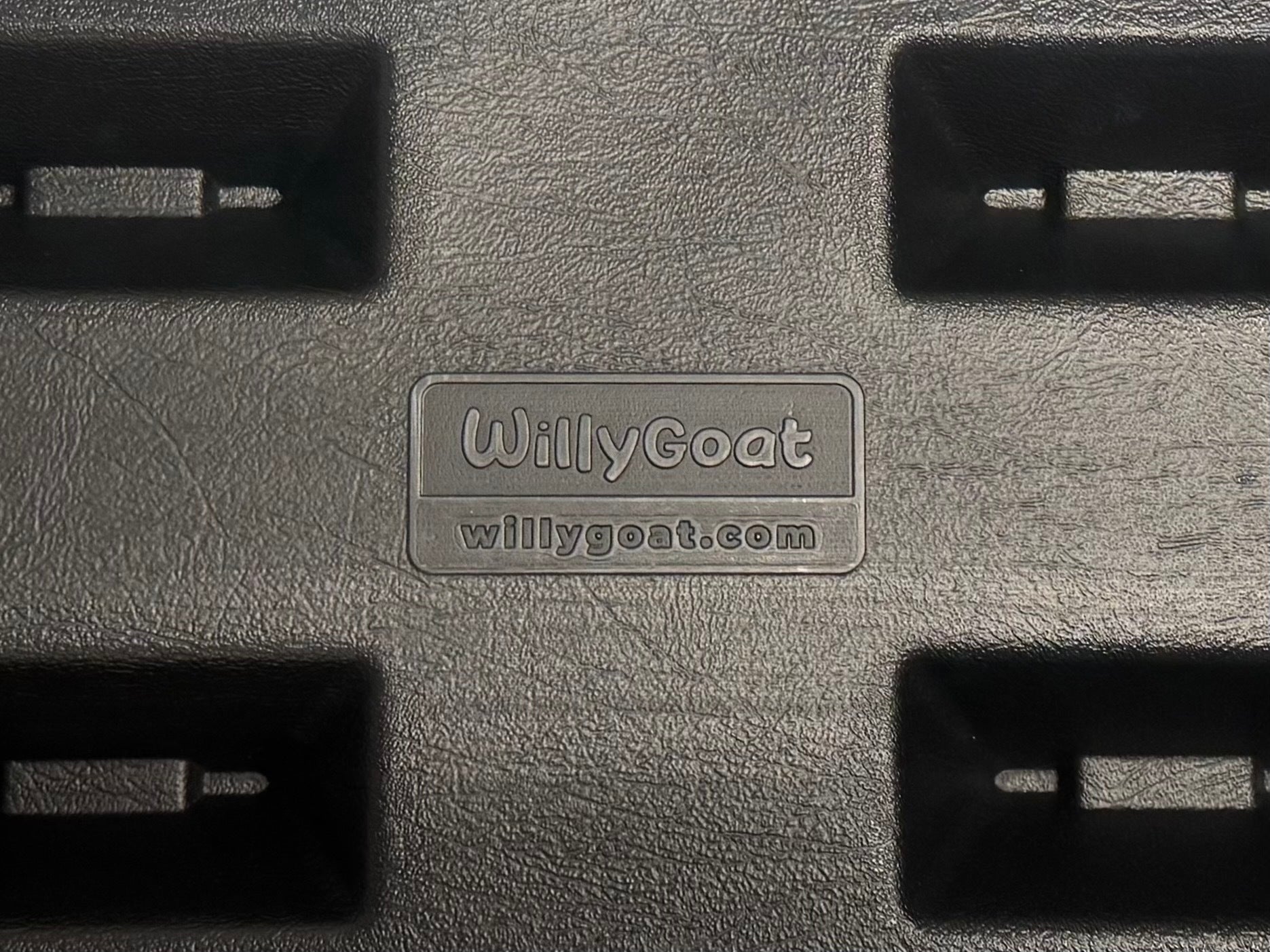 Black textured plastic playground border with rectangular recesses and embossed brand name and website, featuring a spike for ground installation