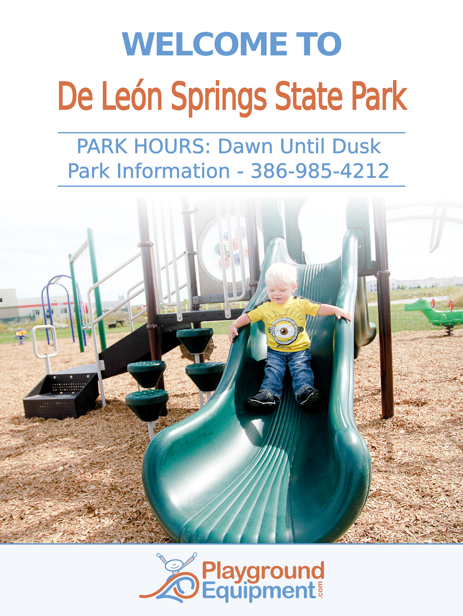 Child in yellow shirt sliding down green playground slide with climbing structure and wood chip ground cover beneath