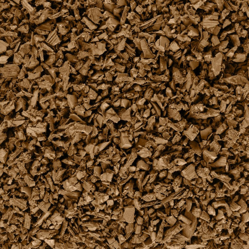 Tan coated rubber mulch pieces with irregular, textured shapes for durable playground surfacing