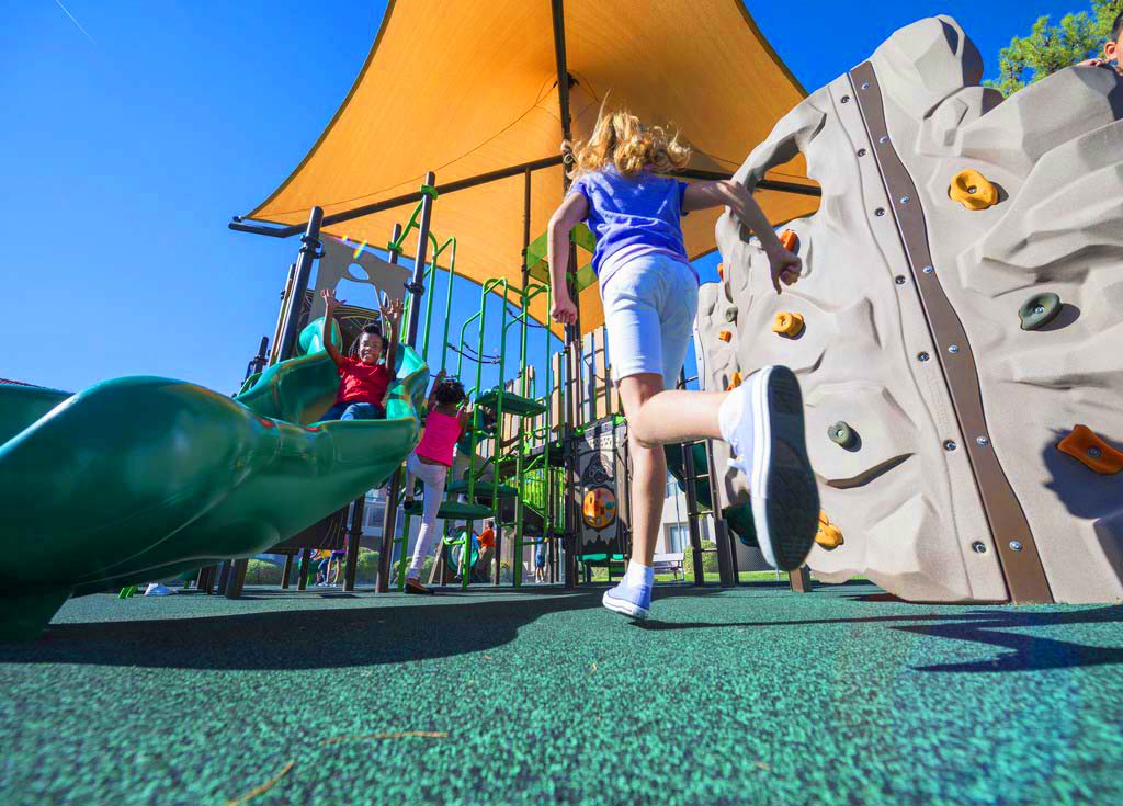 Girl Running on Playground with Pour in Place Surfacing and Shade Structure