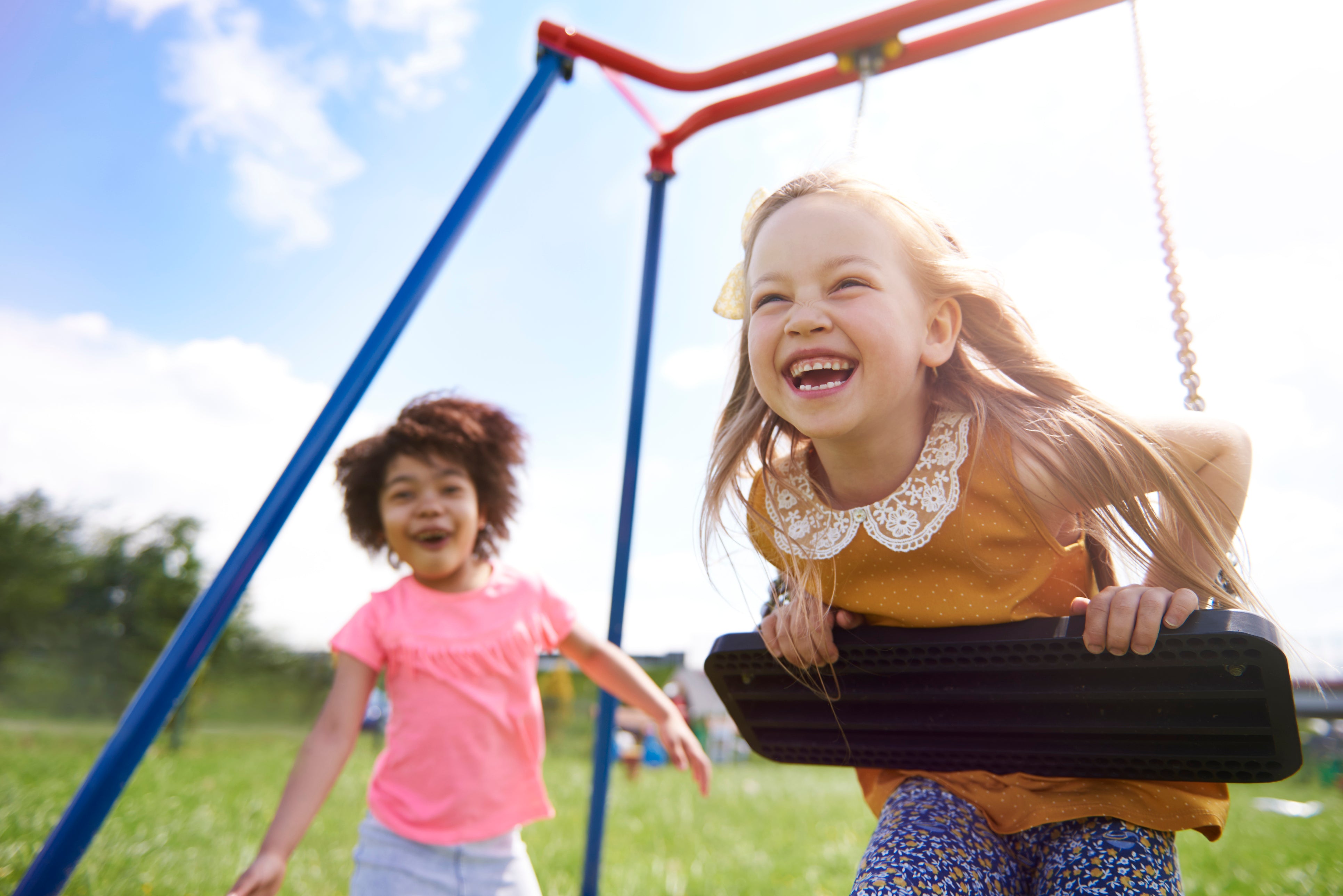 Girls Playing on a swing in a playground