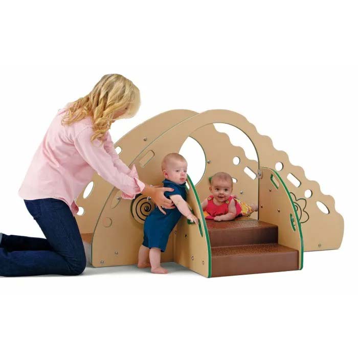 Natural-colored toddler playground with soft ramp, climbing arch, interactive panels, and two babies playing nearby