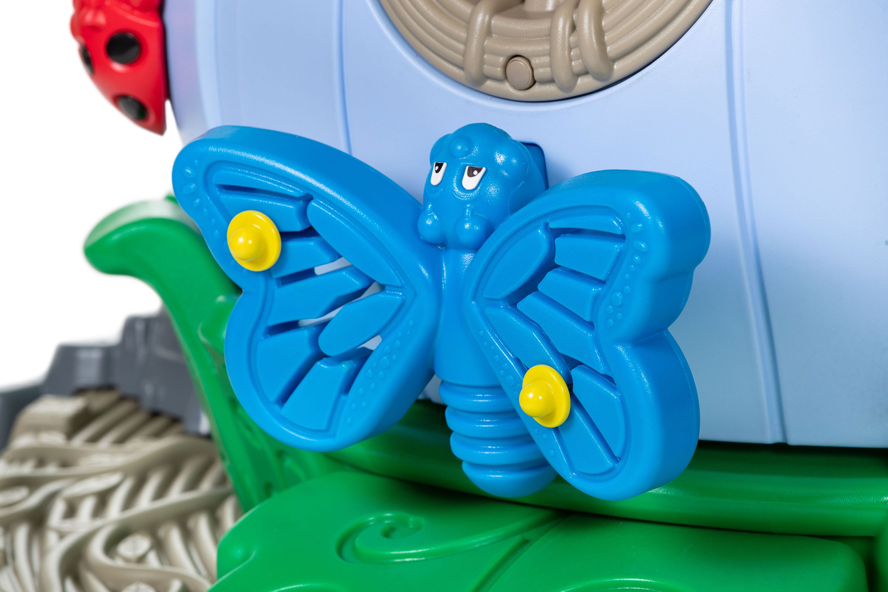 Blue butterfly spinner with yellow knobs on green leaf panel, ladybug accent; Happy Hollow play system sensory component