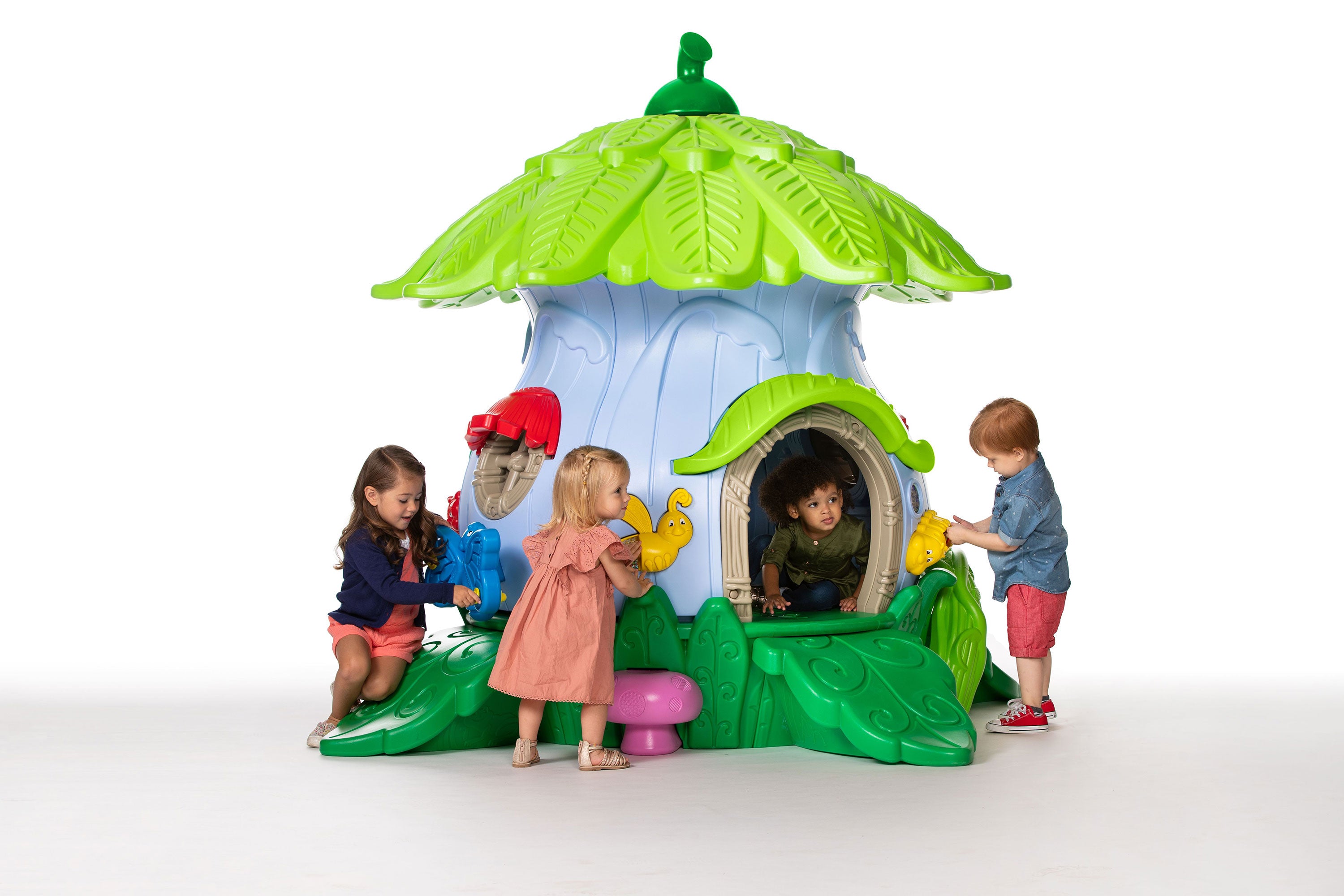 Nature-themed toddler playground with leaf roof, doorway, and sensory panels, four preschoolers on white backdrop.