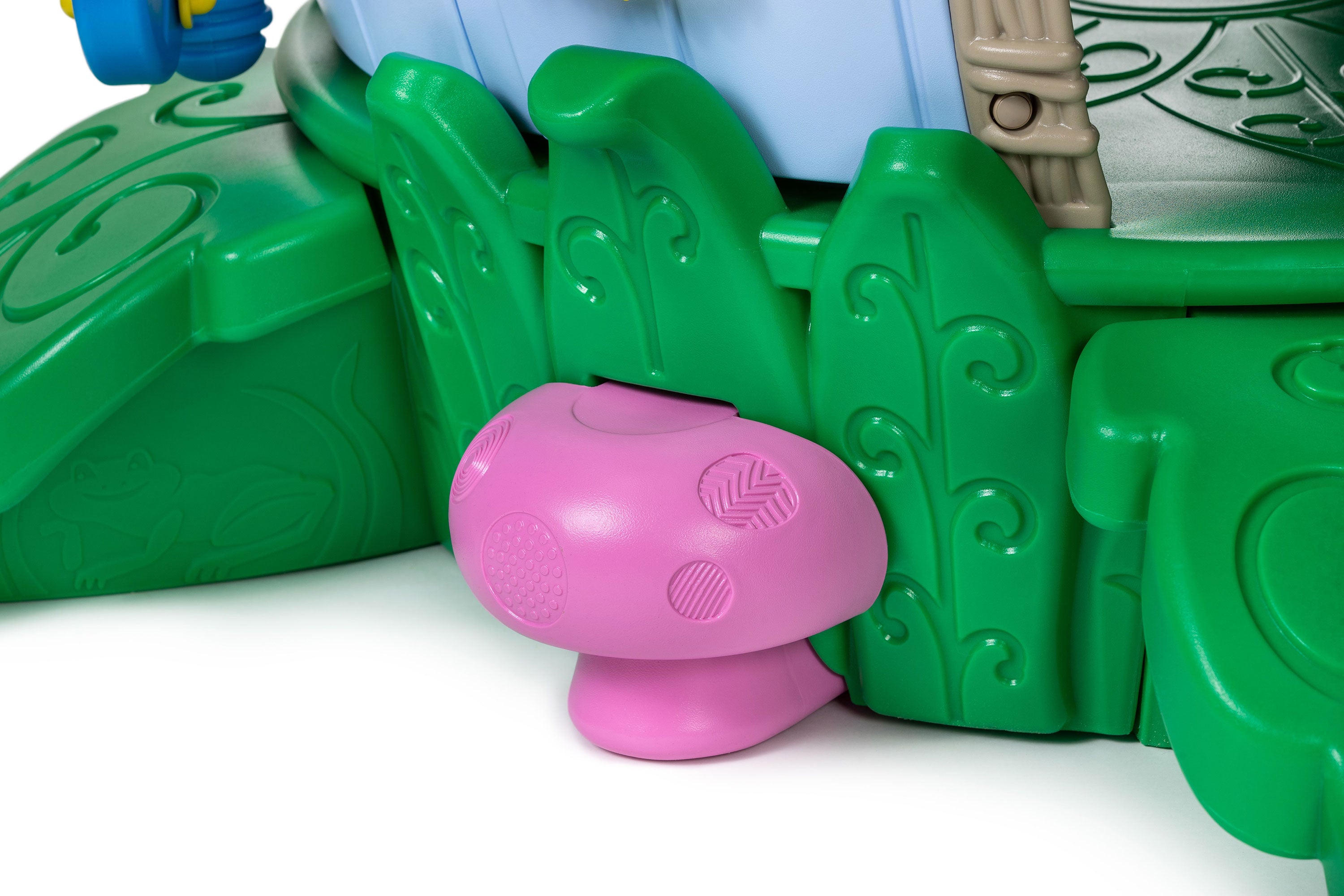 Pink mushroom interactive sensory button with tactile patterns on green leaf panels of a nature-themed toddler playground