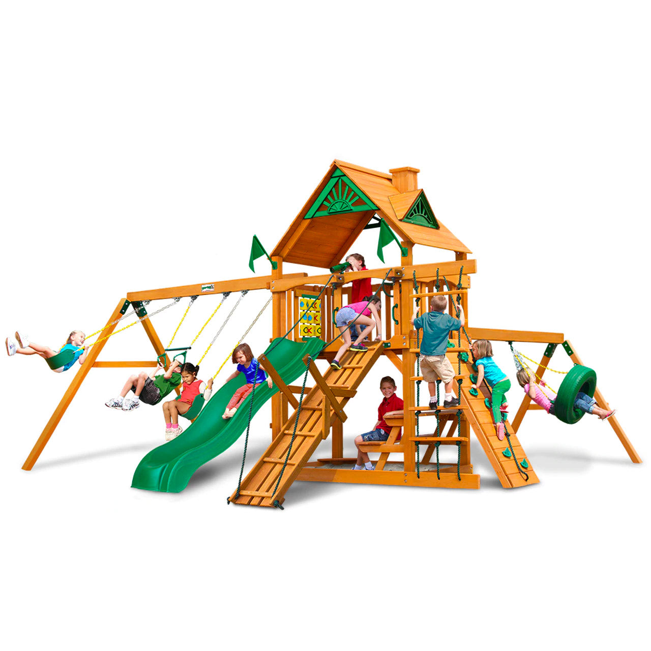Cedar wooden playset with green slide, swings, climbing ramp, tire swing, picnic table, and kids playing outdoors