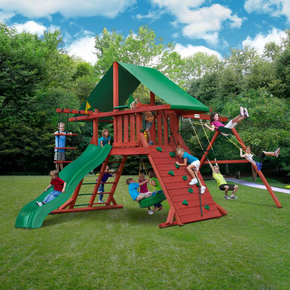 Redwood wooden swing set with green vinyl canopy, Alpine Wave slide, rock climbing wall, tire swing, and multiple belt swings on grass lawn