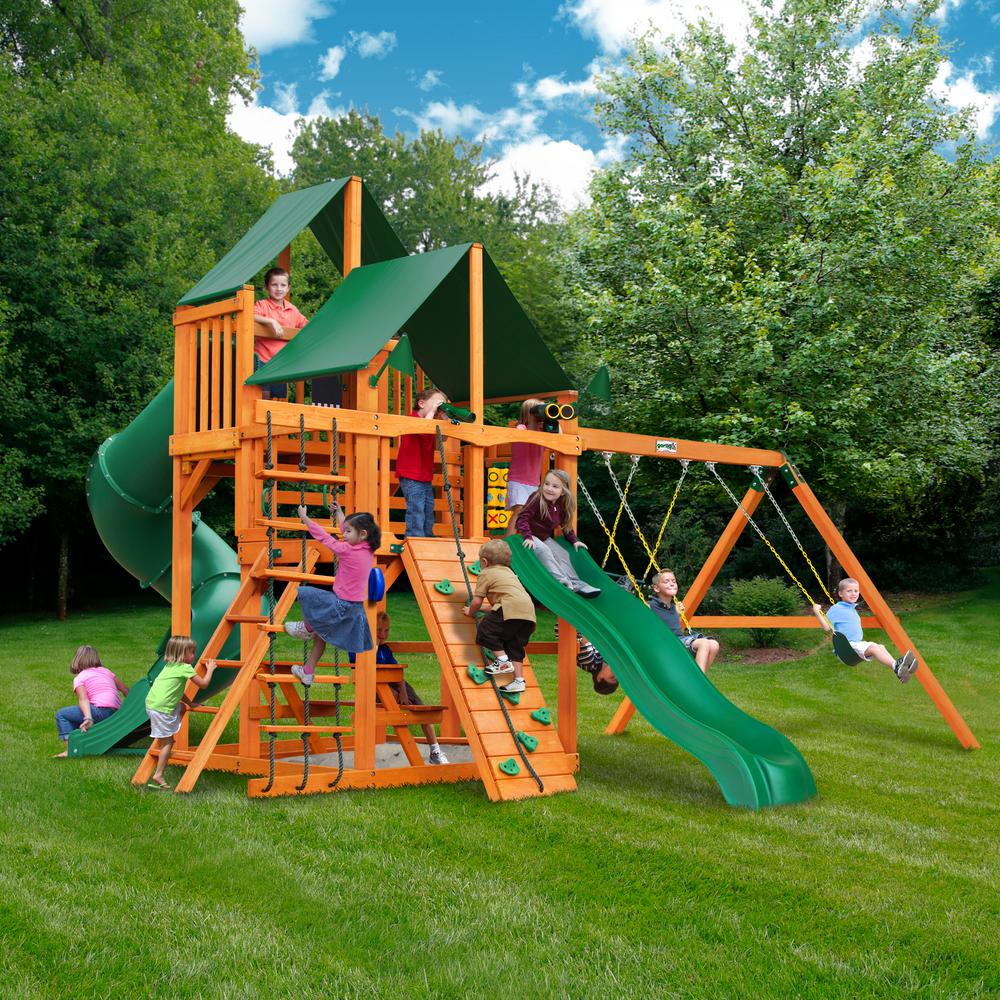 Wooden playset with green vinyl canopy roofs, green slide, climbing wall, rope ladder, dual swings, trapeze swing, and children playing outdoors