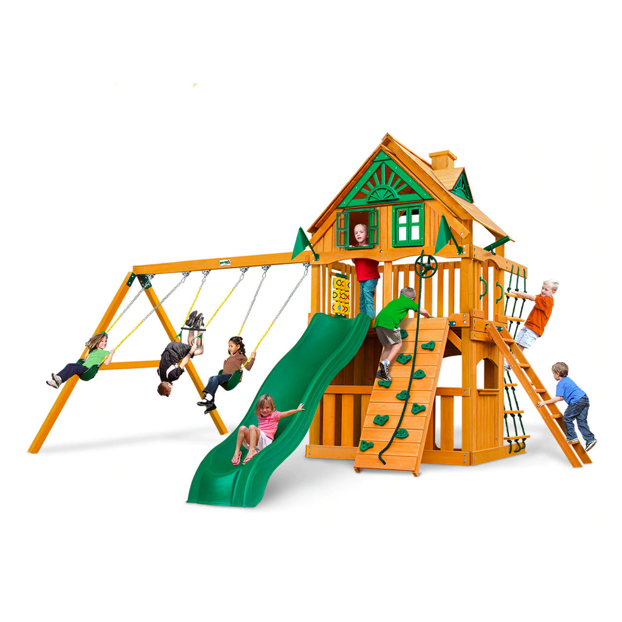 Cedar wooden playset with green slide, two belt swings, trapeze swing, climbing wall, rope ladder, and clubhouse with windows and decorative roof