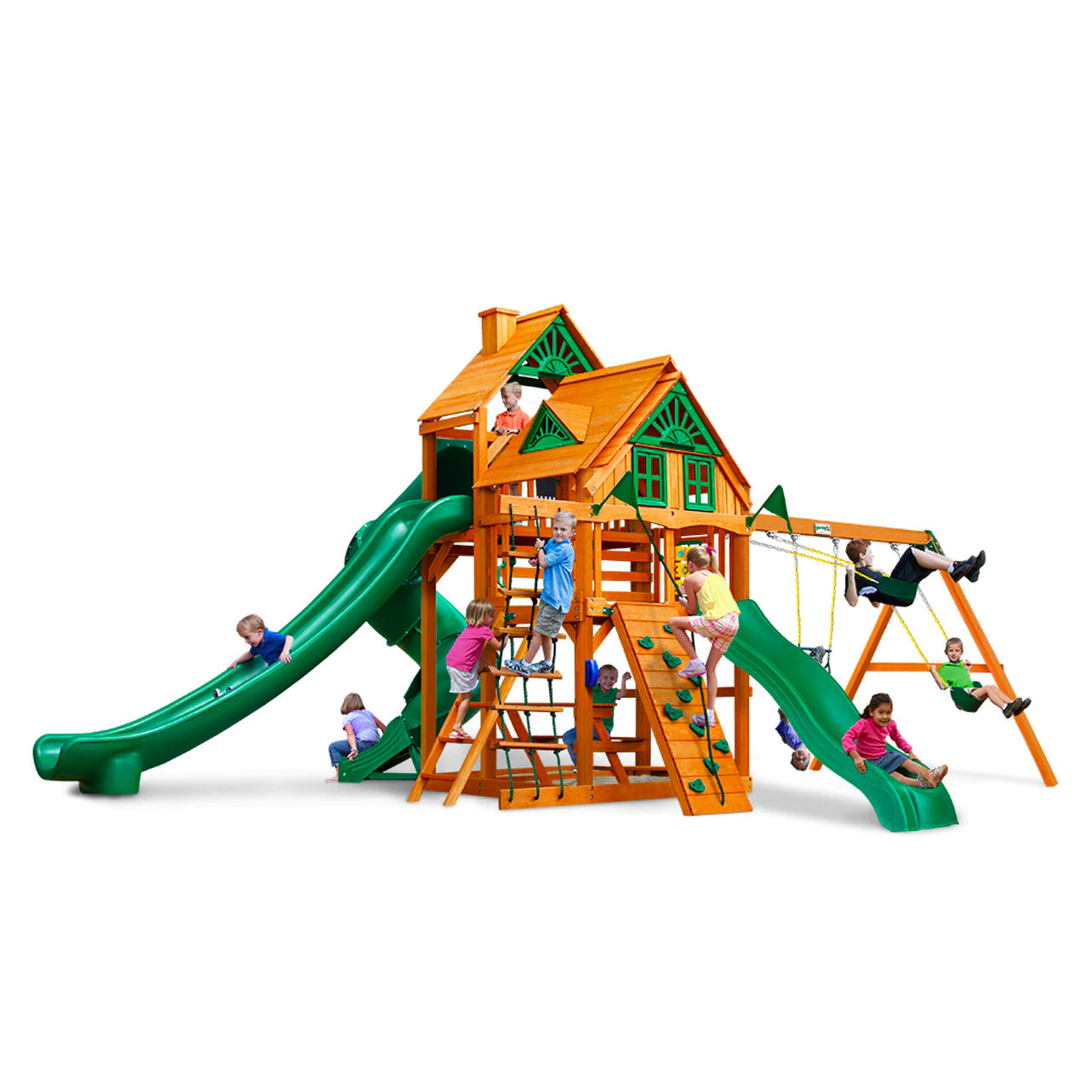 Cedar wooden playset with two green slides, climbing wall, rope ladder, swings, and children playing outdoors
