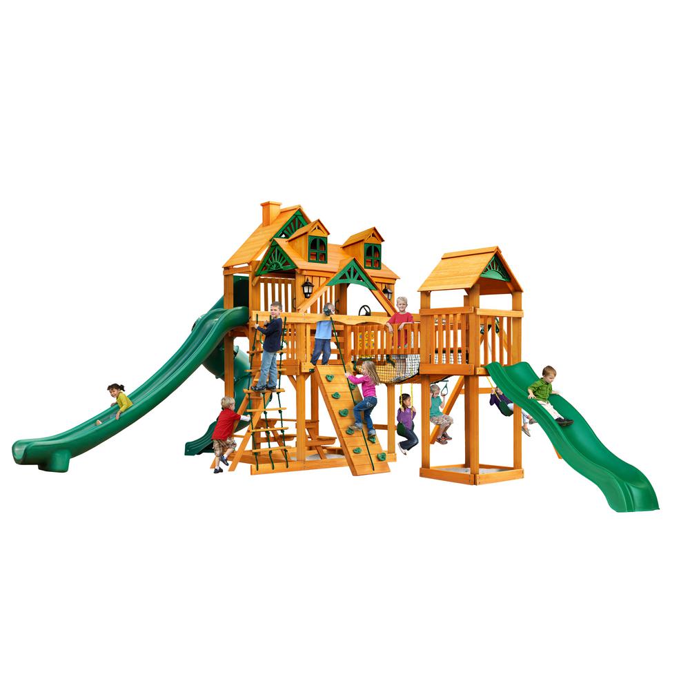 Wooden playset with two green slides, climbing wall, rope ladder, swings, and children playing outdoors