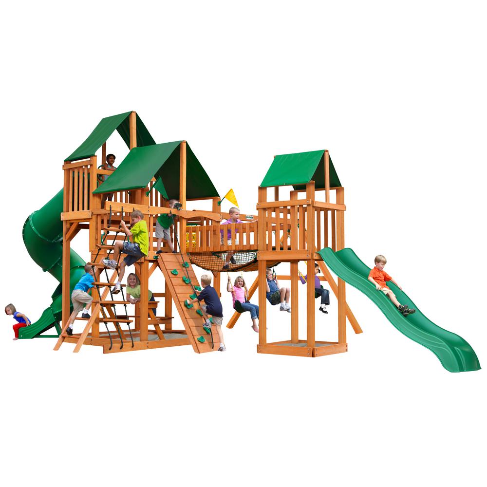 Wooden playset with green vinyl canopies, multiple slides, climbing walls, swings, and children playing outdoors