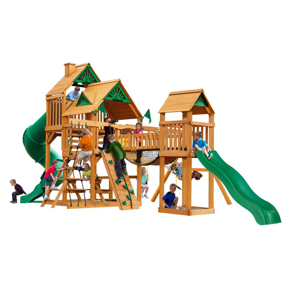 Treasure Trove I AP Wooden Swing Set with natural cedar wood, green slides, climbing walls, rope ladder, and wood-roofed play towers