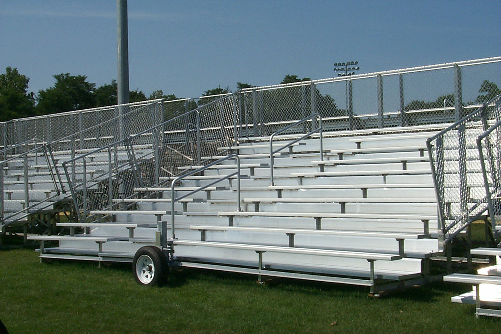 10 Row Deluxe Portable Bleachers with aluminum seats, chain-link guardrails, handrails, and wheels on grass field