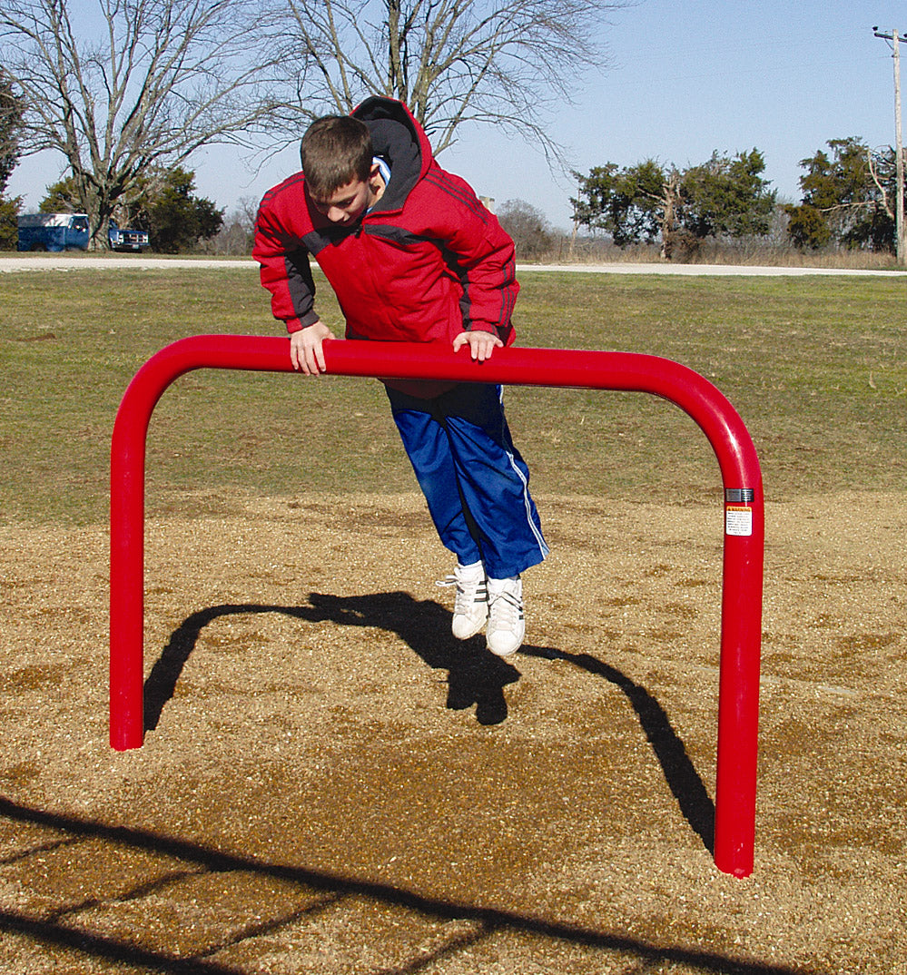 Boy in red jacket performing a dip on a bright red galvanized outdoor fitness bar over gravel surface