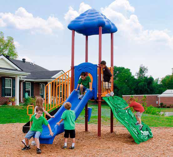 Children playing on a compact playground structure with a blue slide, green climbing wall, and shaded roof outdoors