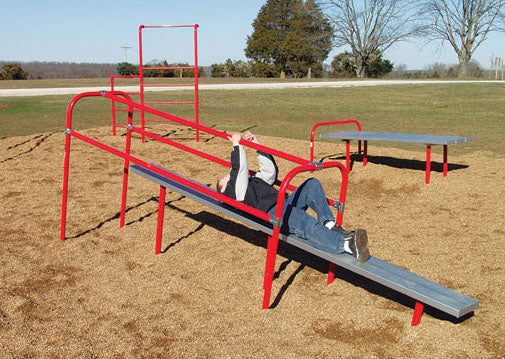 Outdoor fitness course section with red galvanized aluminum pull slide and climbing bars on mulch surface