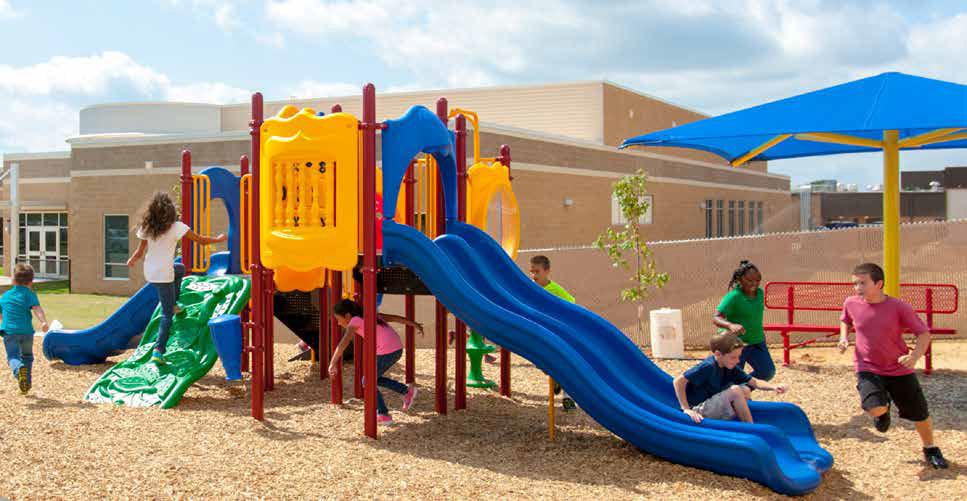 Colorful playground with double blue slides, climbing panels, crawl tunnel, and children playing under a blue shade canopy