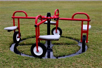 Red mini merry-go-round with four white seats and black wheels on green grass, designed for young children’s play and exercise