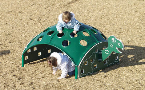 Green turtle-shaped climbing structure with circular cutouts and children playing on playground surface