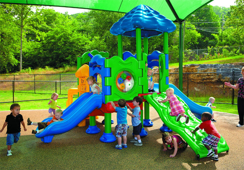 Colorful toddler playground with slides, climbing wall, activity panels, sensory play features, and shaded seating area