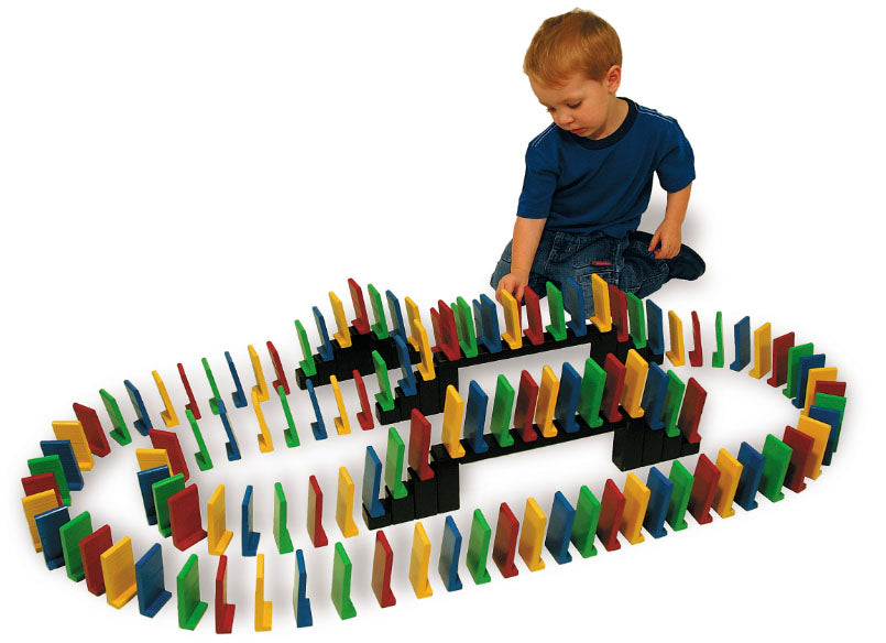 Easy Stand Domino Set with colorful, extra large dominoes and bridges arranged in a pattern around a child playing on the floor