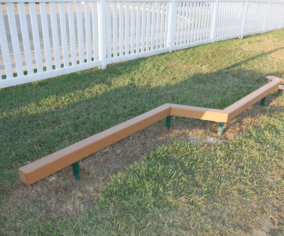 Outdoor zigzag balance beam made of recycled plastic lumber on grass near white fence promoting coordination and fitness