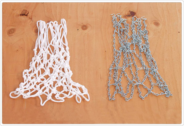 Steel Chain Replacement Net for SportsPlay Basketball Goals next to white nylon basketball net on wooden surface