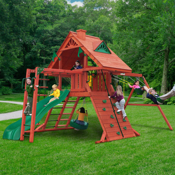 Sun Palace II Wooden Swing Set With Monkey Bars in redwood finish featuring slide, rock wall, tire swing, and children playing outdoors