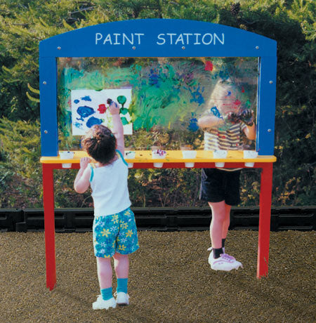 Playground Paint Station with double-sided clear polycarbonate surface and paint shelf, children painting outdoors on commercial play equipment